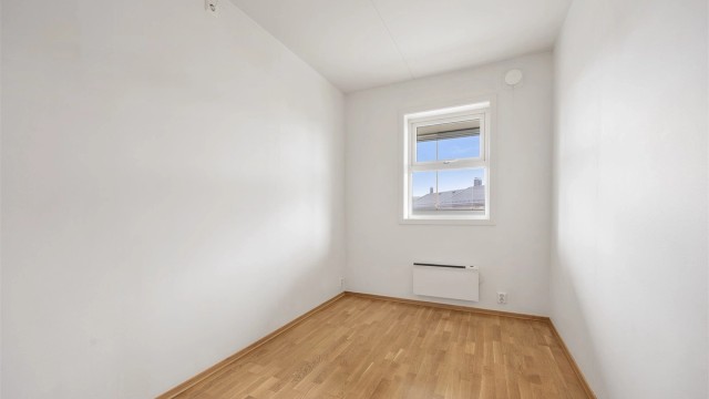Soverom med parkett på gulvet og plass til seng eller kontorpult.