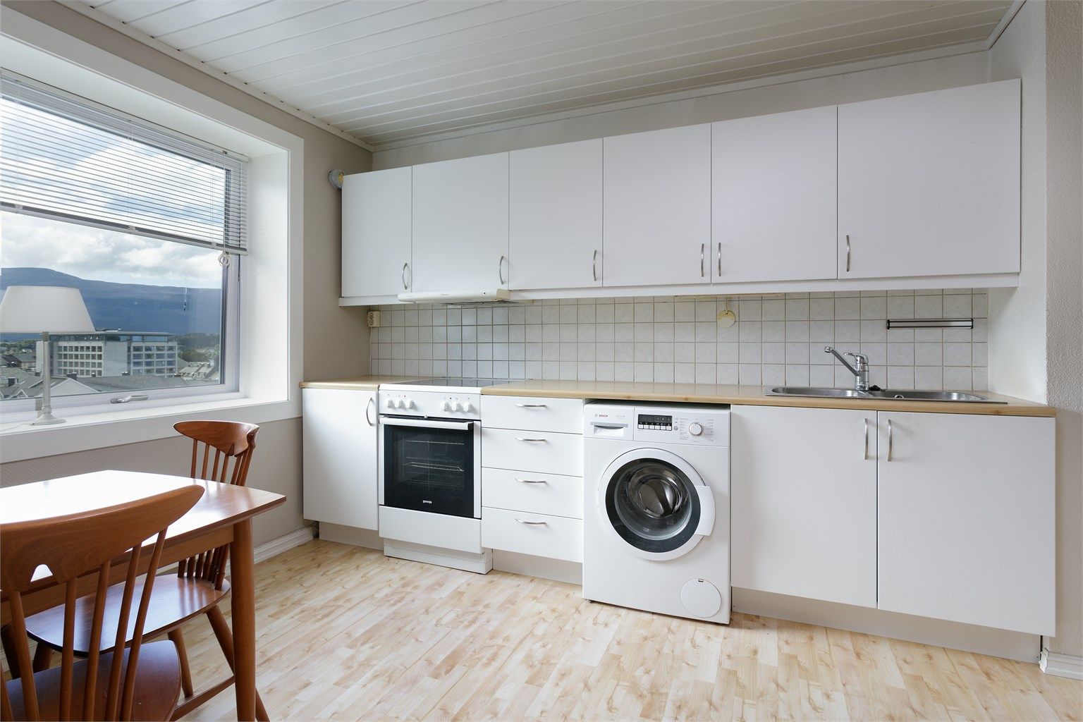 Kjøkkeninnredning med glatte fronter. God plass til spisebord på kjøkkenet