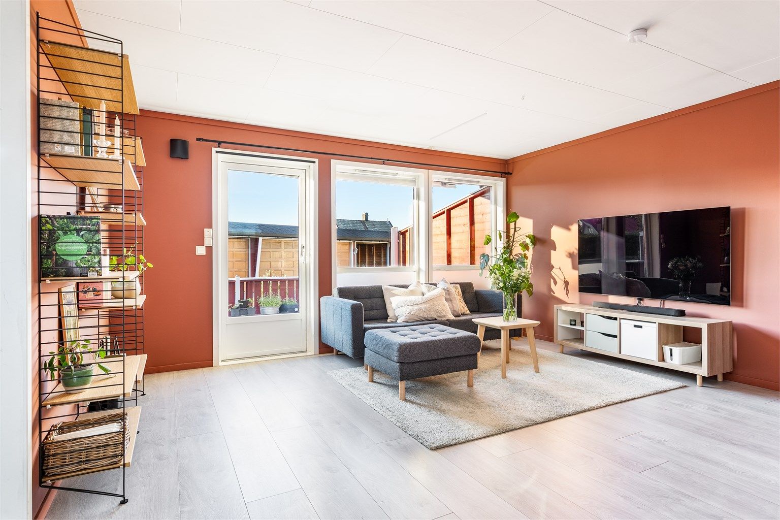 Malerarbeid er siden 2023 utført i de fleste rom, stuen inkludert. Vindusrekke mot vest fyller stuen med solstråler og mye naturlig lys.