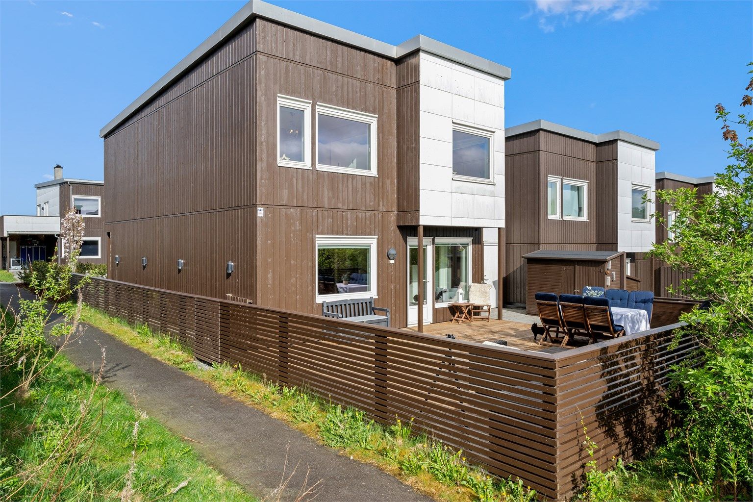 Foran har boligen en stor solplatting som er inngjerdet. Det er adkomst fra gårdsrommet ved innkjørselen eller gjennom garasjen/boden samt direkte fra stue.