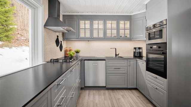 Pent IKEA kjøkken med innredning med profilerte fronter. Benkeplaten er av laminat. Integrert gassbluss, induksjonstopp, micro og stekeovn. Plass til oppvaskmaskin kjøle/fryseskap.