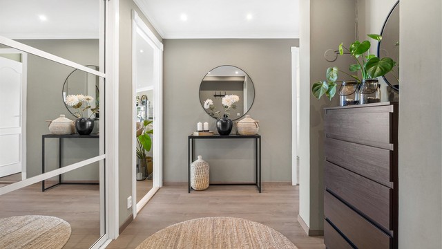 Romslig entré med en stor skyvedørsgarderobe som gir rikelig med oppbevaringsplass.