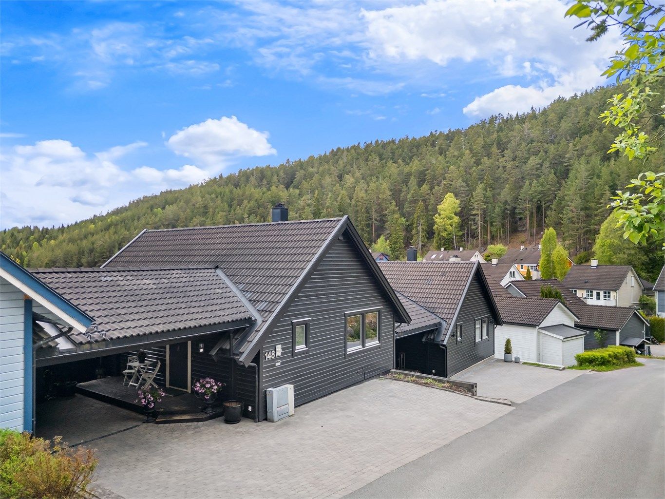 Ved inngangspartiet er det en carport på ca. 32 m² og gårdsplassen er belagt med belegningsstein.
