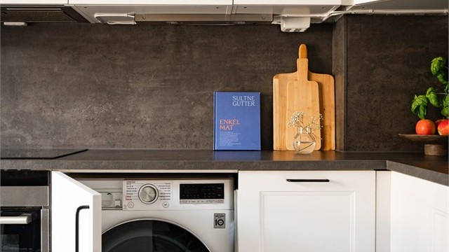 Kjøkkenet har også en smart løsning med plass for vaskemaskin integrert i innredningen.