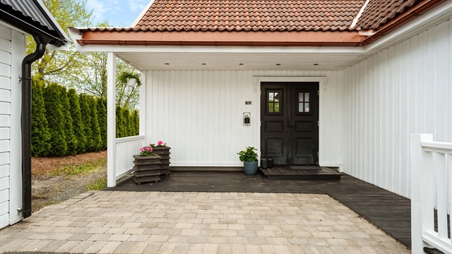 Overbygd inngangsparti med en platting på 10 kvm med utvendige downlights i tak.