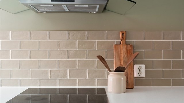 Kjøkkenet har integrerte hvitevarer som induksjonsplatetopp, stekeovn, oppvaskmaskin, kjøleskap og fryser