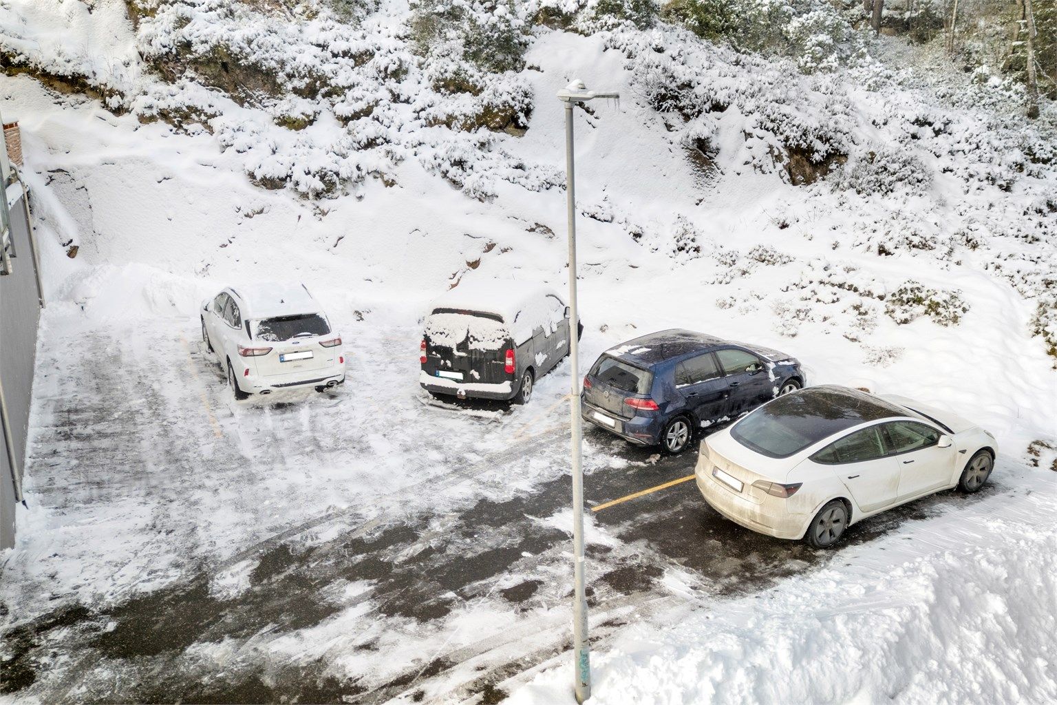 Gjesteparkering utenfor med 5 biloppstillingsplasser på byggets høyre side. 