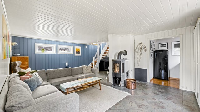 I underetasjen er det innredet til en lun og koselig kjellerstue med peisovn.