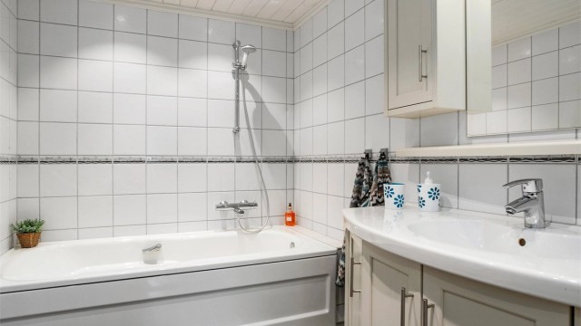 Badet er innredet med både badekar og dusjnisje.