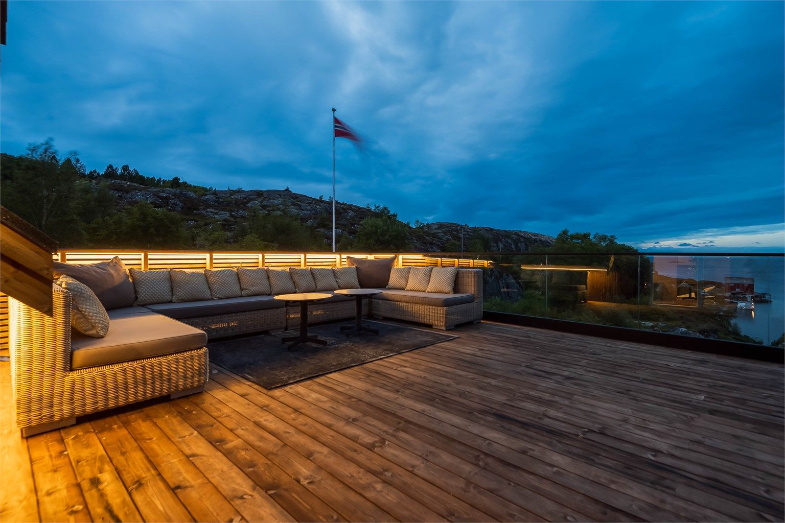 Terrassedekke av Royal terrassebord og rekkverk i heldekkende glass for å kunne nyte utsikten.