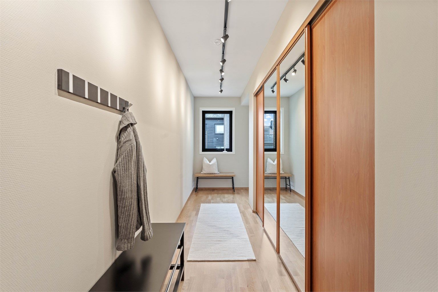 Romslig entré med stor skyvedørsgarderobe som gir rikelig med oppbevaringsplass.