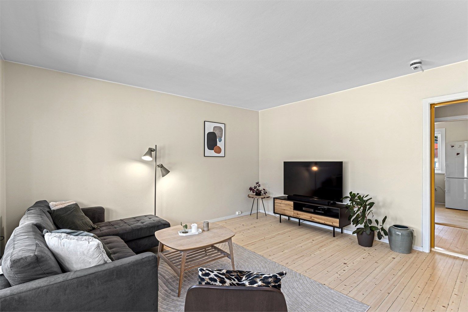 Lys og romslig vestvendt stue med plass til både sittegruppe og spisebord