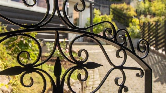 En elegant, sort smijernsport med dekorative detaljer markerer adkomsten til eiendommen