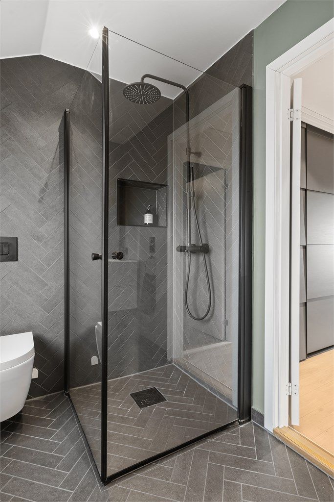 Dusjnisje med innfellbare dører og regnskogdusj, integrert hylle i dusjvegg. 