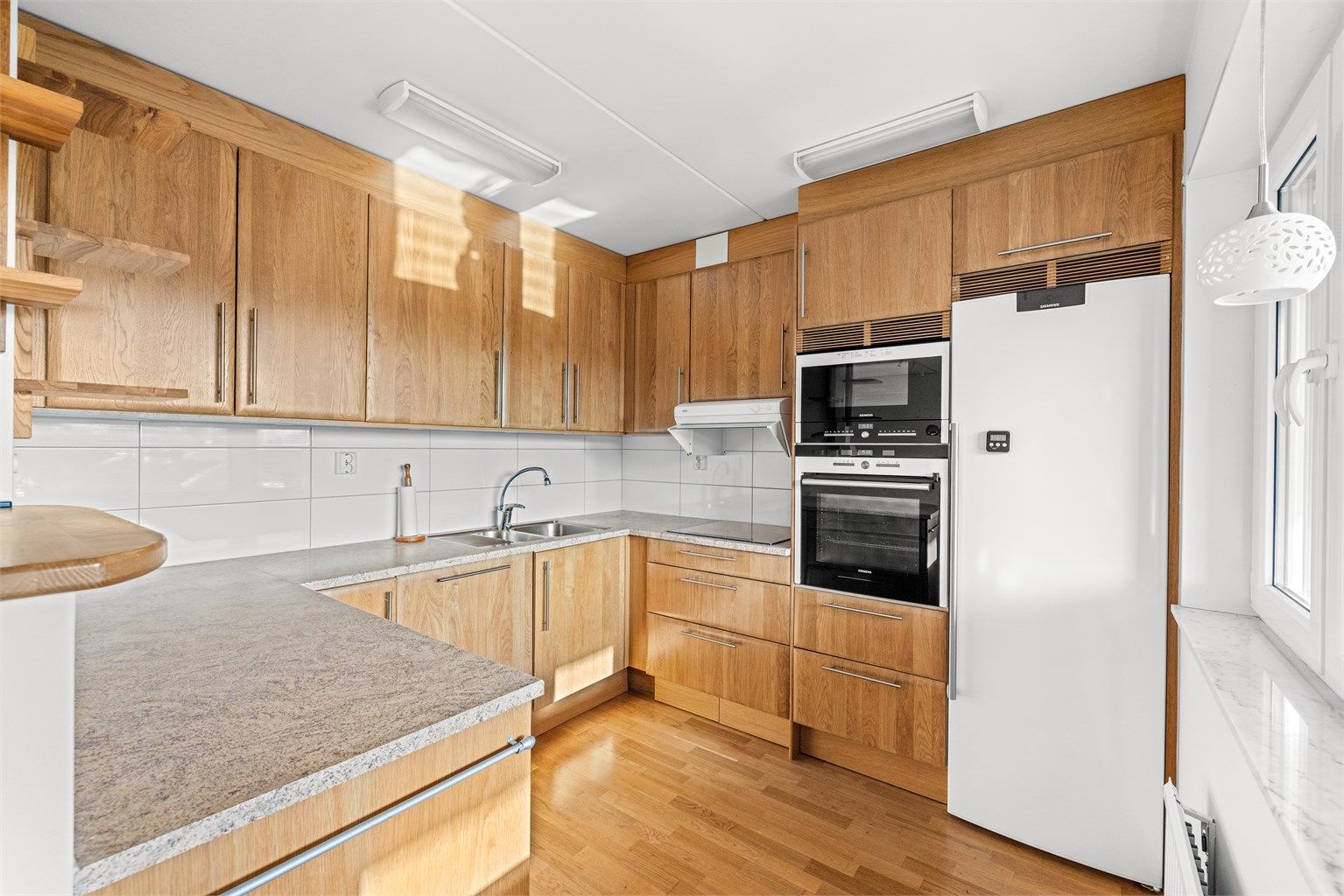 Kjøkkenet har integrerte hvitevarer som koketopp, stekeovn, mikro og  oppvaskmaskin