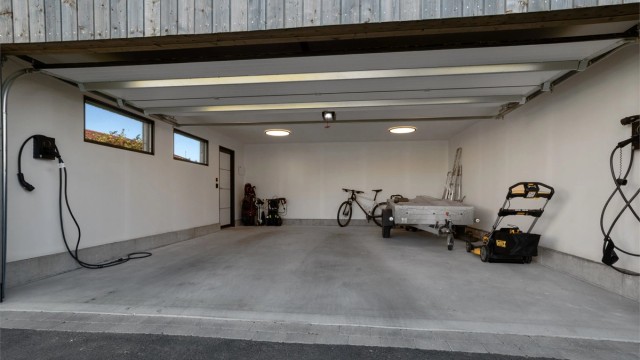 Frittstående dobbelgarasje fra 2025 med leddport, isolerte vegger og god lagringsplass.