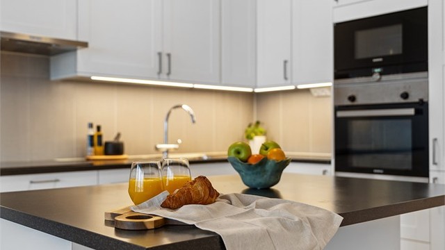 Kjøkkenøy med laminatbenkeplate og plass til sitteplasser – et sosialt midtpunkt.