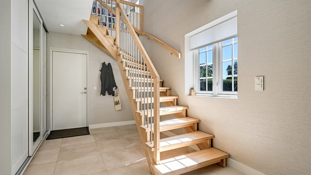 Hall/gang i sidefløyen gar gjennomgående materialvalg skaper et helhetlig inntrykk.