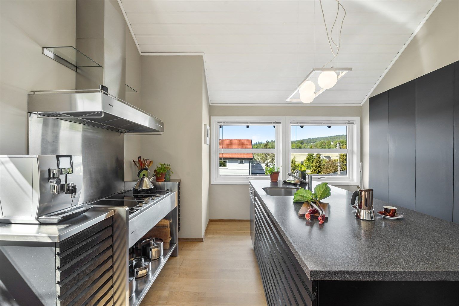 Praktisk kjøkkenøy med barløsning og underskap med spilefronter (spilefronter fra 2019), pent plassert i midten av rommet.