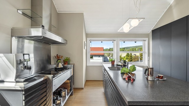 Praktisk kjøkkenøy med barløsning og underskap med spilefronter (spilefronter fra 2019), pent plassert i midten av rommet.