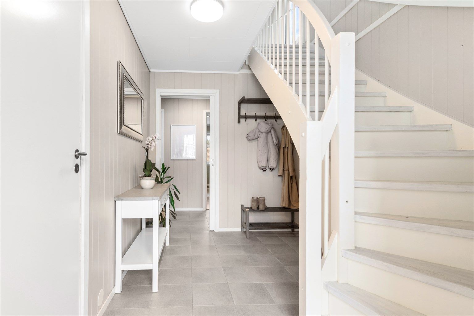 Fra gangen fører trappen opp til andre etasje. Varmepumpen er strategisk plassert i trappegangen for effektiv varmefordeling.