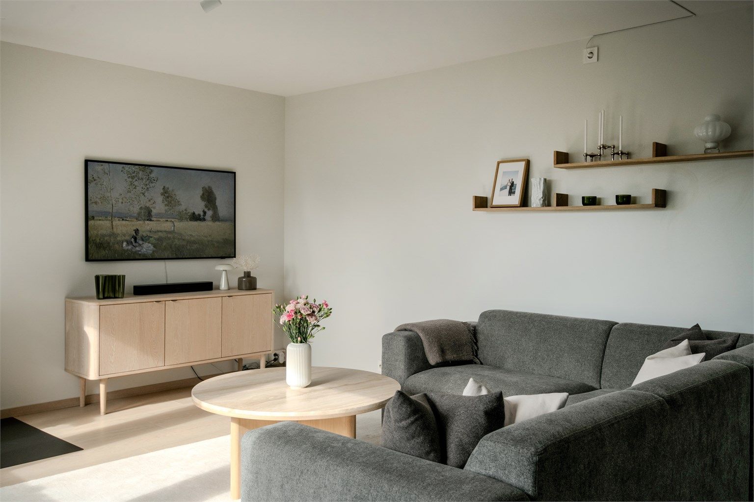 Store vindusflater gir rikelig med naturlig lys og skaper en behagelig atmosfære i stuen.