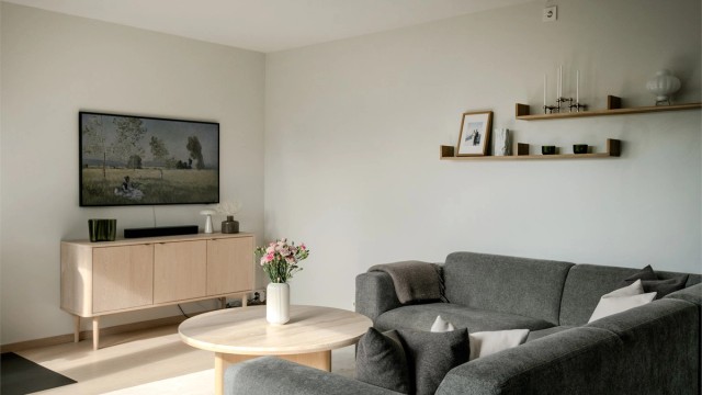Store vindusflater gir rikelig med naturlig lys og skaper en behagelig atmosfære i stuen.