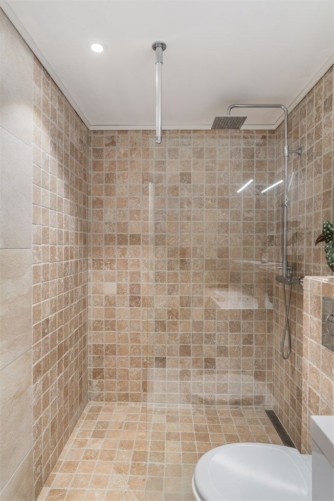 Rommet har dusjhjørne med glassvegg og opplegg for vaskemaskin.