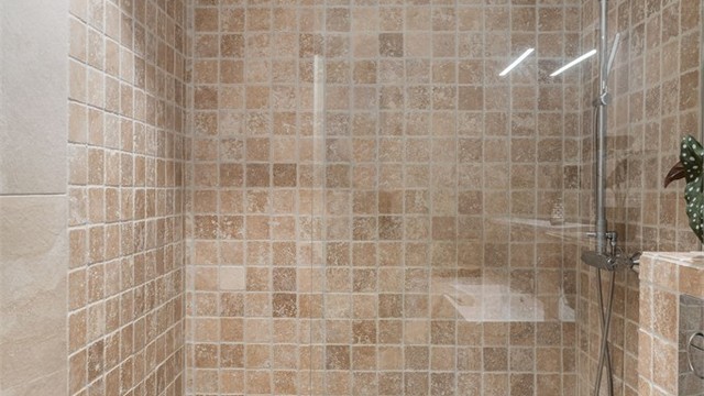 Rommet har dusjhjørne med glassvegg og opplegg for vaskemaskin.