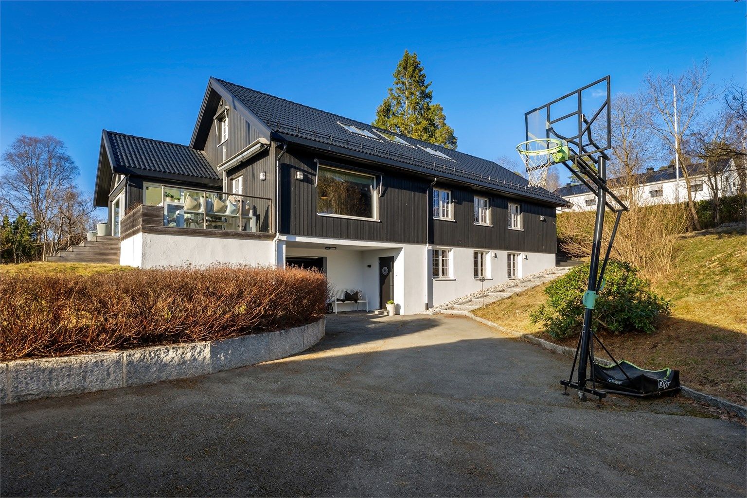 Tomten er pent opparbeidet med asfaltert oppkjørsel, støttemur av stein, plenarealer og diverse beplantning