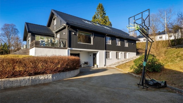 Tomten er pent opparbeidet med asfaltert oppkjørsel, støttemur av stein, plenarealer og diverse beplantning