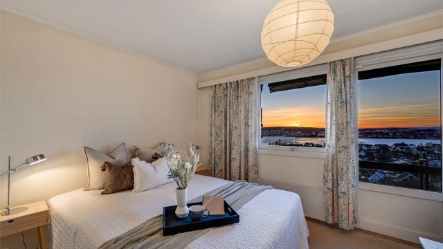 Lyst og innbydende soverom med store vindusflater og flott utsikt.