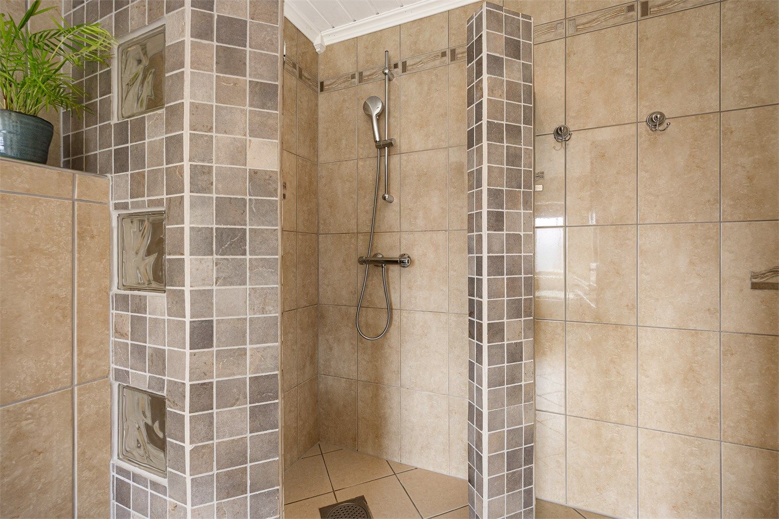 I tillegg til badekar har badet en separat dusjnisje med flislagte vegger.