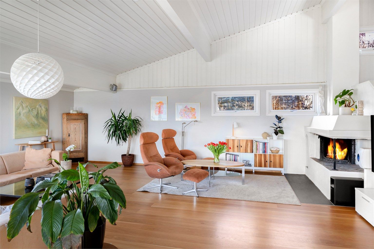 Stuen har malt panel i taket og på deler av veggene, noe som gir rommet en klassisk karakter.