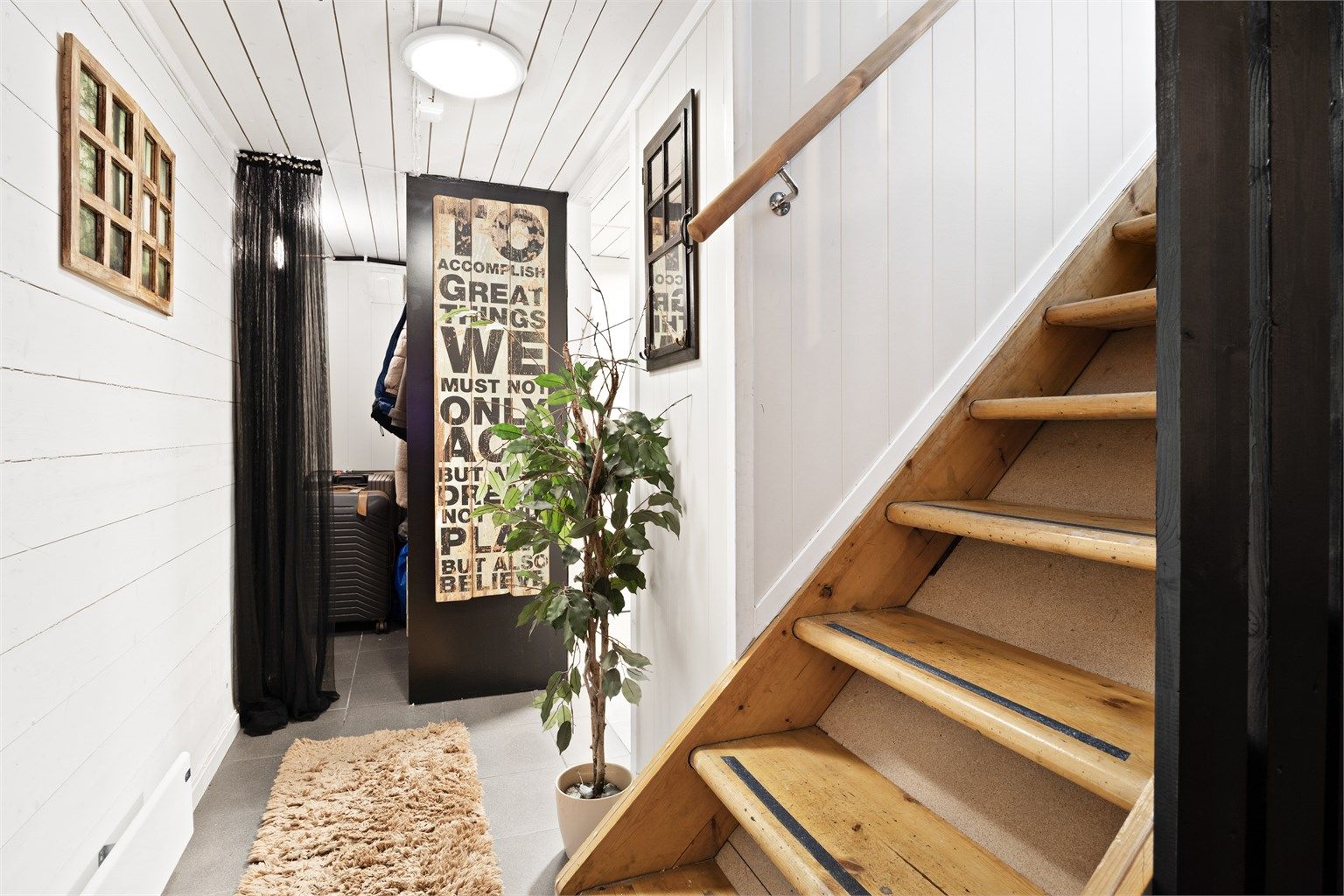Tretrappen leder ned til kjelleretasjen. Romslig garderobe/bod ved vaskerom.