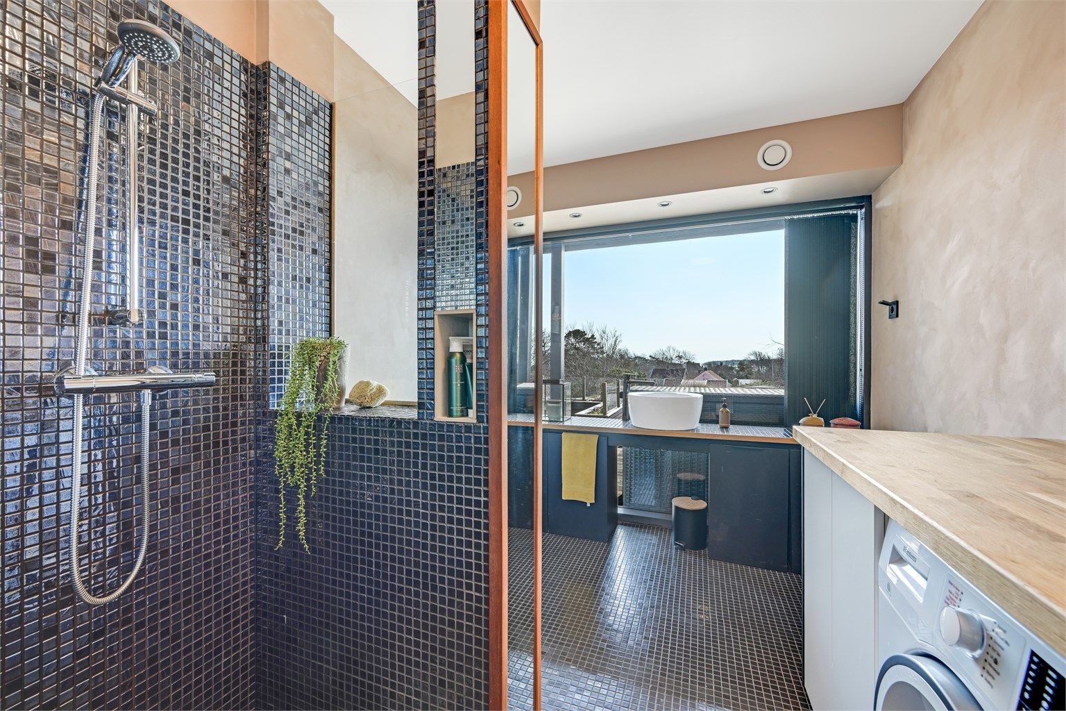 Badet i første etasje fungerer også som vaskerom. Rommet har flislagt gulv med varmekabler.