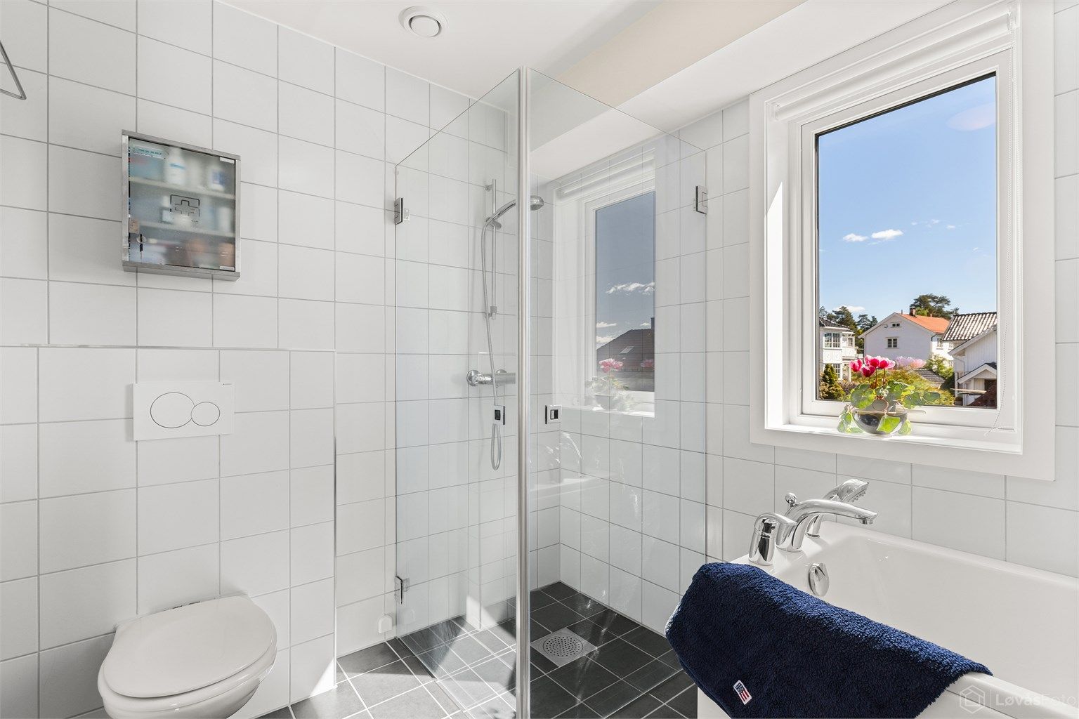Badet er utstyrt med både badekar og et dusjhjørne med innfellbare glassdører