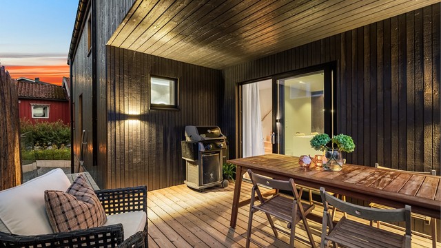 Terrassen i andre etasje er belagt med impregnerte terrassebord og har rekkverk i glass og stål.