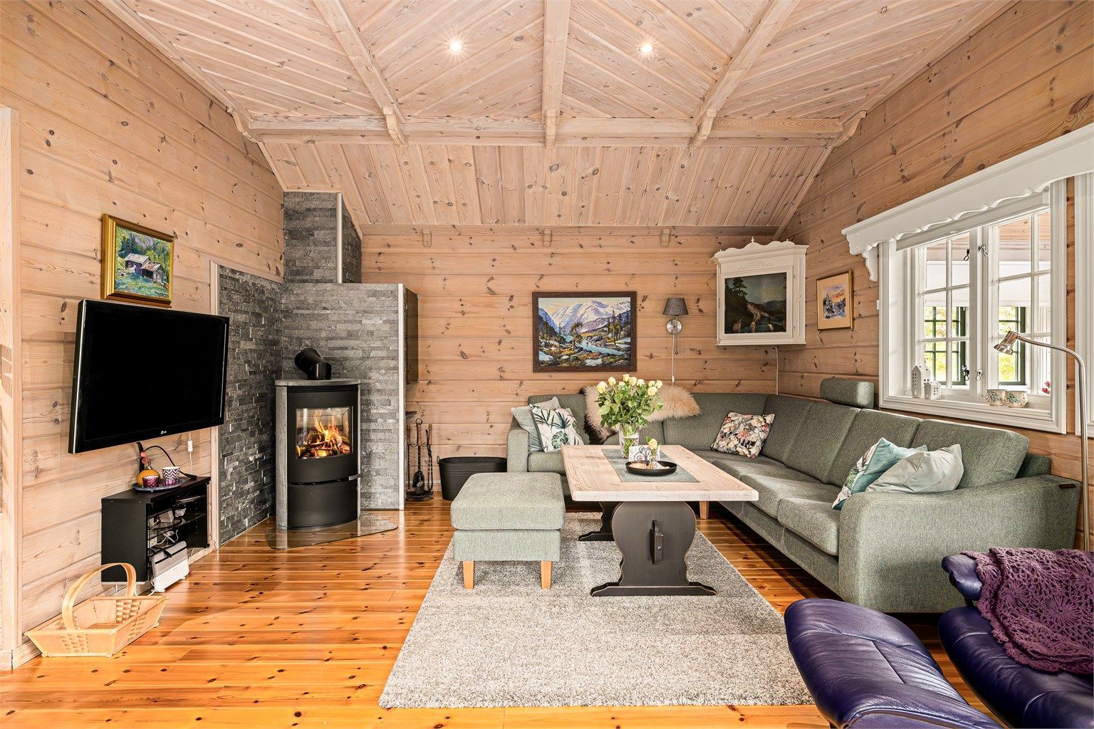 Stor stue med peisovn som skaper en varm og koselig tilværelse. 