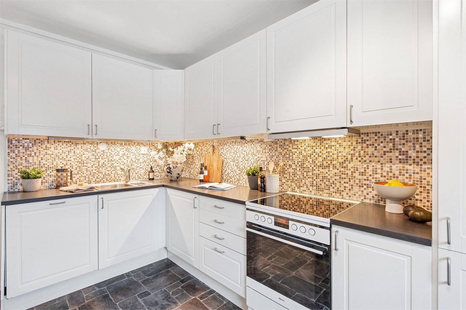 Kjøkkenet har gode arbeidsflater og plass til et lite spisebord.