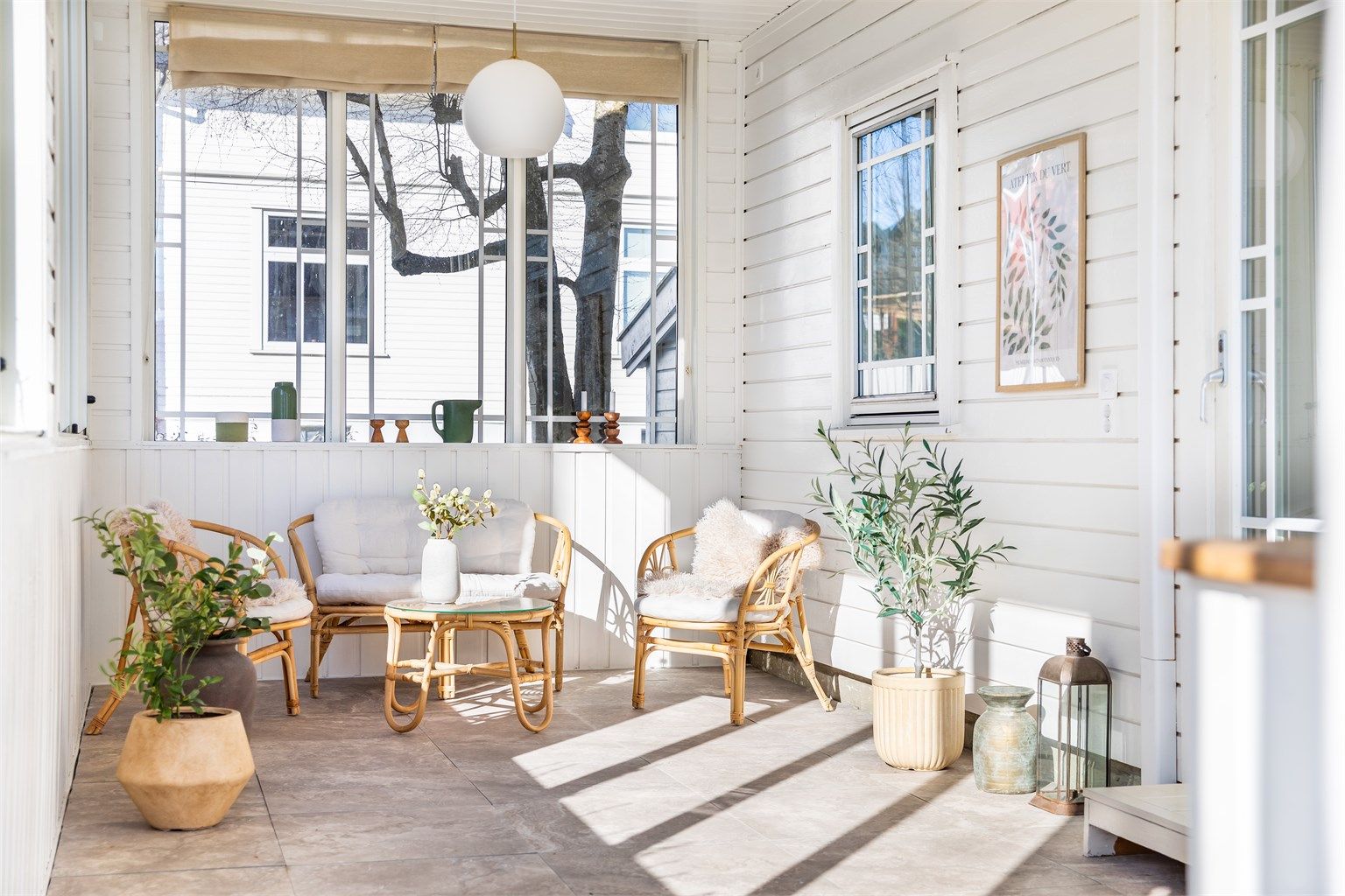 Flisheller er nylig lagt over terrassebord på vinterhagens gulv, øvrige overflater er malt hvite.