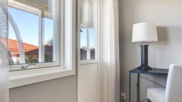 Fra dette soverommet er det utgang til den overbygde markterrassen og hagen.