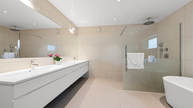 Badet har gulvvarme, innfelte spotter, dusjhjørne med glassvegg og frittstående badekar.