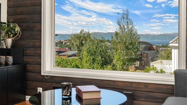 Det store vinduet rammer inn den flotte utsikten og gir oppholdsrommet en lys og luftig atmosfære. Man har fjordutsikt både fra 2. og 3. etasje.