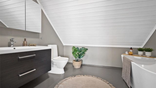 Rommet er utstyrt med badekar, toalett og en servant med god oppbevaringsplass.