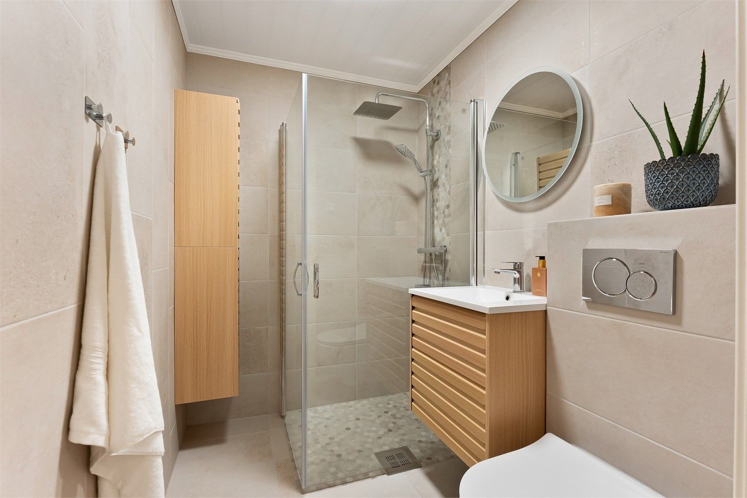 Baderommet i første etasje fikk oppgraderte overflater i 2023, med fliser på gulv og vegger.