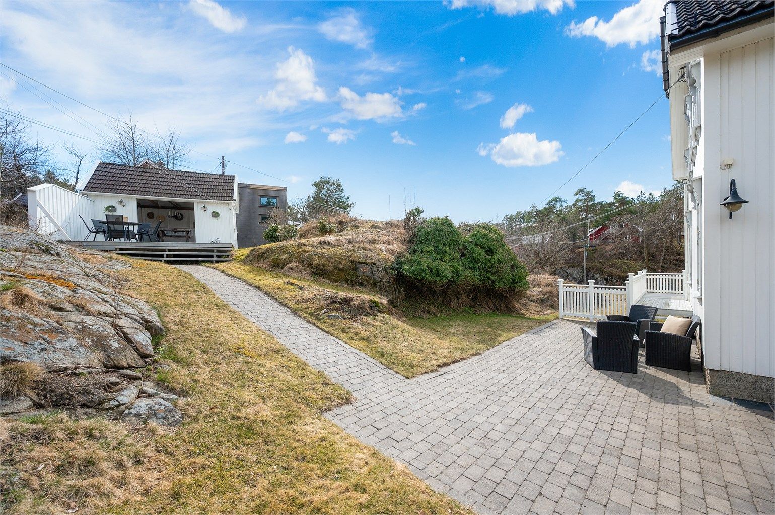 God plass for utemøblementer over ulike soner på tomten. Lettstelt og praktisk med belegningsstein rundt boligen.