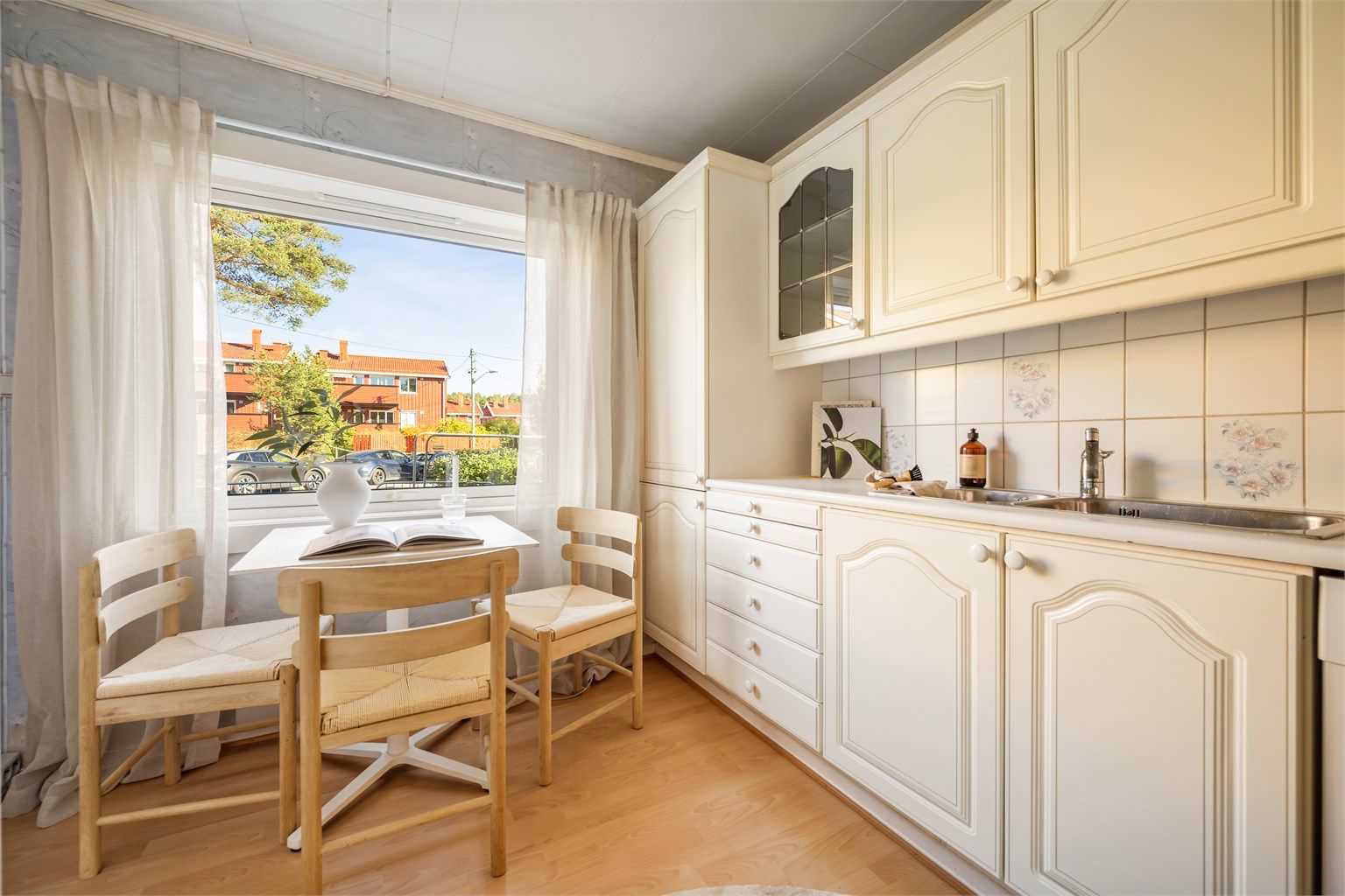 Kjøkkenet har et stort vindu som slipper inn godt med dagslys. Innredningen byr på rikelig med oppbevaring, og det er plass til spisebord ved vinduet.