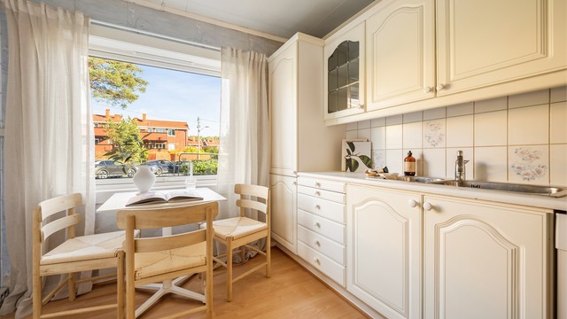 Kjøkkenet har et stort vindu som slipper inn godt med dagslys. Innredningen byr på rikelig med oppbevaring, og det er plass til spisebord ved vinduet.