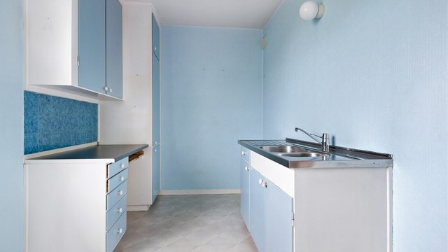 Kjøkkenet har slette fronter, laminert benkeplate og oppvaskkum i rustfritt stål.